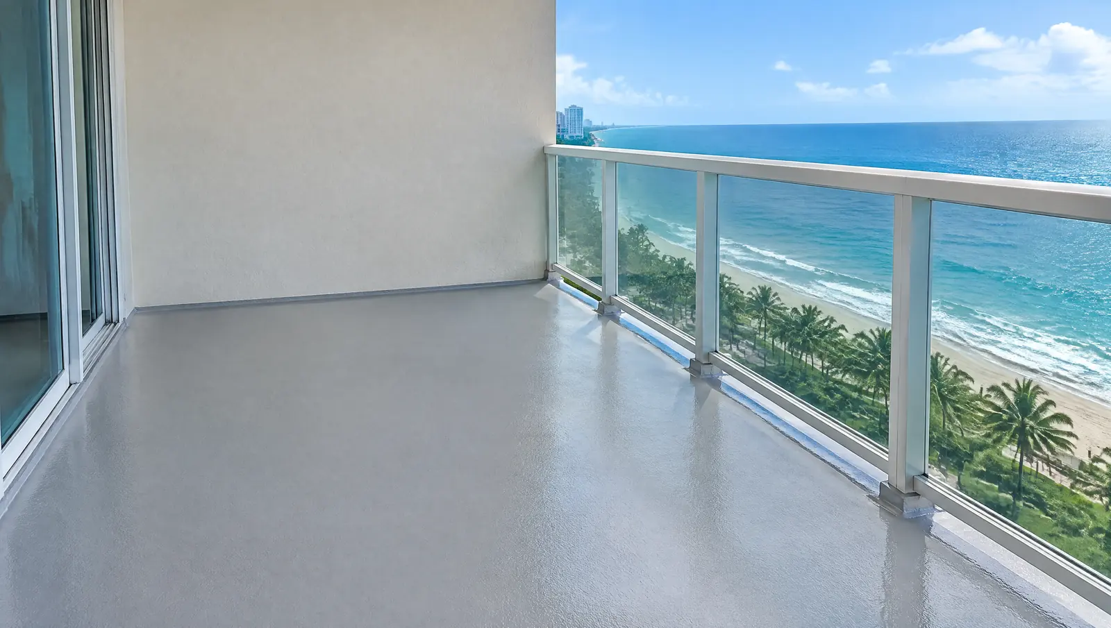 Condo balcony deck with a fresh grey waterproof coating and glass railing overlooking the ocean